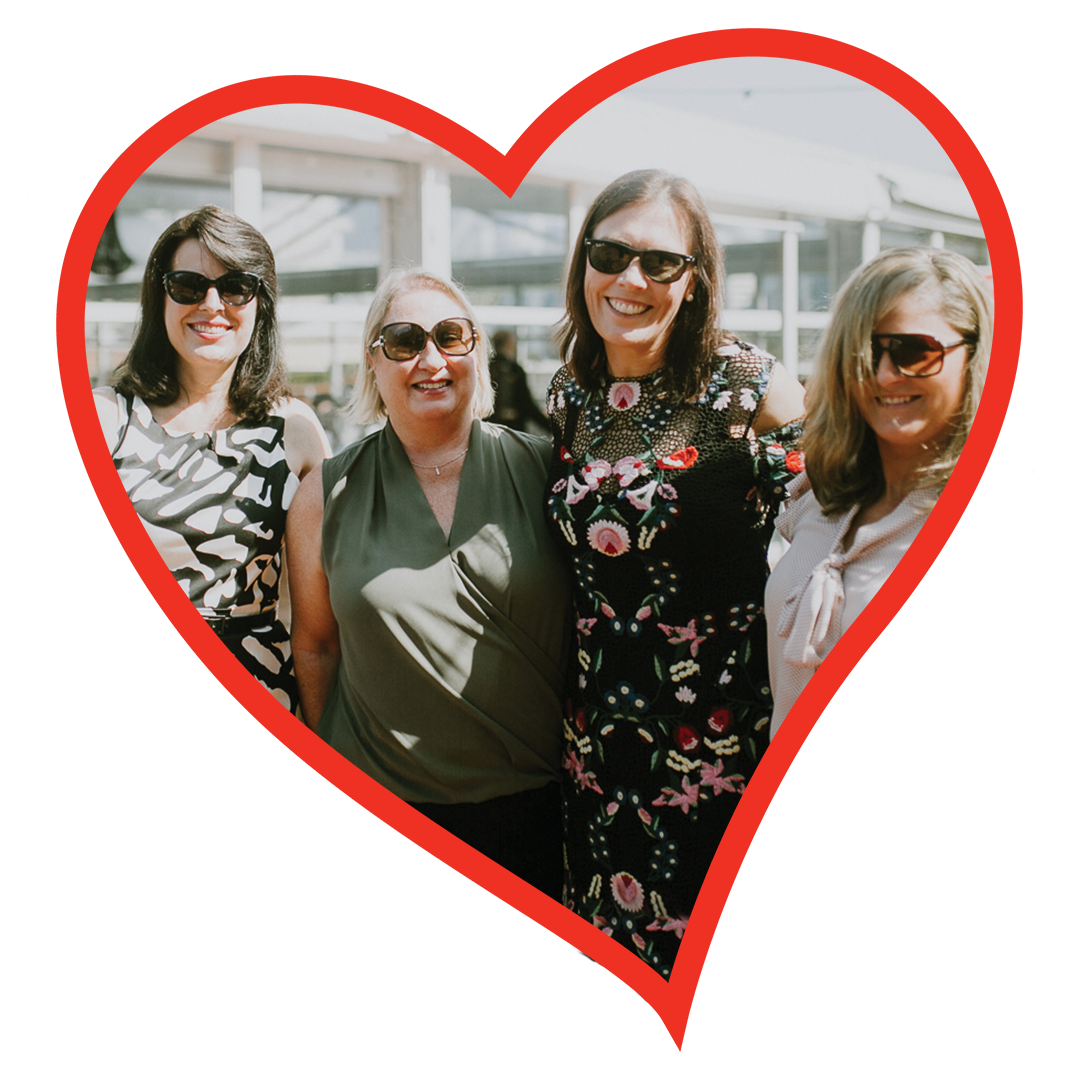 Four women wearing sunglasses smiling