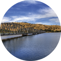 Lake Hume Bridge over calm waters. The hills in the background are dry and yellow. The sky is blue and cloudy. Lake Hume Bridge over calm waters. The hills in the background are dry and yellow. The sky is blue and cloudy.